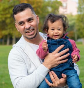 man holding a baby girl with a disability